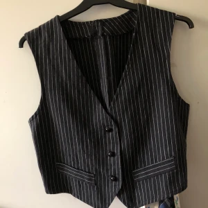 Vintage Väst - Så cool och unik väst att ha under polotröjor eller en vanlig t shirt. Hittade på secondhand men använder den inte tyvärr. I perfekt skick och bra kvlite då bomullen är tjockt vävd. Frakt 44, passar mig bra som är xs men har då justerat midjan som ni ser på bilden. Passar därför större storlekar. Kontakta mig för exakta mått. SKICKA DM FÖR BILD PÅ!