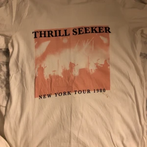 T-shirt med tryck - Vit t-shirt med rosa tryck i strl XS. En liten fläck under trycker, säljs därför billigt. Skriv om du vill ha bättre bilder på plagget, tex passform på kroppen osv!