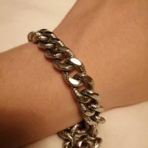 Silvrig kedja - Ganska tjock silvrig kedja som kan användas som armband. Har ett inristat mönster som får kedjan att se ut som en silvrig orm🐍🤍