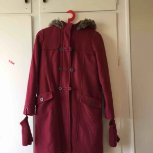  - Super fin och charmig vinter kappa med dragkedja och knappar. Fodrad med jättefint tyg, luvan är fejk päls och har söta små handleds värmare som går att knäppa av. Använd ett fåtal gånger och är i oerhört gott skick.  Från LaRedoute av Verbaudet. 