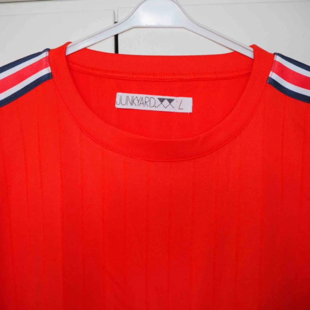 Tshirt i glansigt tyg (som en fotbollströja). Från Junkyard.  En damstorlek L. Mer lik en Medium. 💥 Använd 1 gång.  . T-shirts.