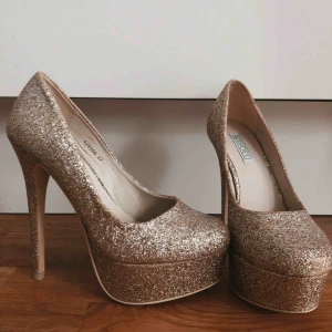  - Glittriga platåklackar från NLY shoes. Aldrig använda. Klacken är 11 cm.