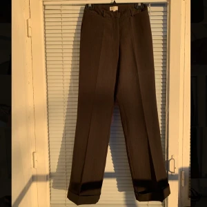 Kostymbyxor (rak modell) - Kostymbyxor i rak modell säljes. Riktigt snygga och säljes enbart då de inte passar mig längre. Strl: 34. Kan skicka bilder på hur de sitter om så önskas. Byxornas material är superbra och har inga skavanker eller liknande. 