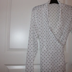 Svart vit prickig blus  - En blus med prickar. Blusen kan knytas runt midjan och ger en fin passform. Den ger även en fin cleavage. Kan levereras i Göteborg zon1 och 2 inom västtrafiks rese handlingar. Helst cash då jag inte har swish. Detta kan dock lösas. Lägg bud 