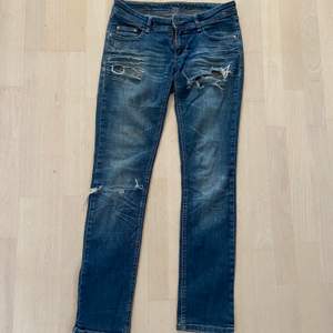 W25 L32 jeans med tre hål, två av de sitter högt på vardera lår o sen ett tredje på knät, low waist 