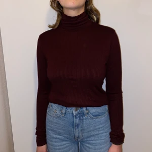 Vinröd ribbad stickad polo  - Storlek S, sitter som M/S. Sitter inte för tajt runt kroppen, bekväm. Sitter lite tajtare i armarna, men inte för tajt utan fortfarande bekvämt. Fin kvalité, använder inte längre:)