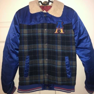 Jacka  -  Blå jacka med fuskpäls. Köpt på Zalando från märket Ebound för ca 1 år sedan. Storlek 164. Inga tecken på användning. 