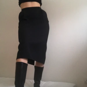 Figursydd pennkjol - Snygg figursydd pennkjol i svart 🔥 storlek 36/38. Jag är 173 cm lång och den går strax över knäna på mig. Kort slits baktill.