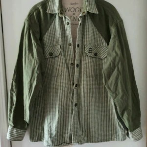 Vintage skjorta - Vintage grön skjortan. Storlek syns inte på lappen men skulle säga ca L. Har en liten fläck nedtill på ena ärmen (se bild 2). Fraktkostnad blir 88kr.
