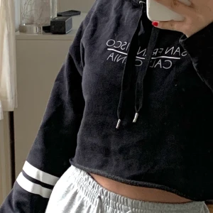 Hoodie - Svart croppad hoodie med texten ”San Francisco California”. Otroligt mjuk innuti känns som filt. Minns ej stlk men skulle säga XS. Fraktar eller möts upp i gbg! 🖤