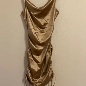 Guld klänning med ribbningar på sidorna skit snygg på 