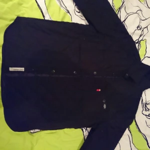  - Dickies Jacka/fodrad skjorta med knäppning, två bröstfickor och två sidfickor. 
