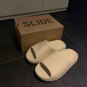  - Adidas Yeezy Slides ”Bone” colourway. De är endast testade inomhus. Dom är lite små i storleken så ska passa 43-44. 