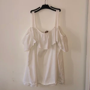 Off shoulder-blus med volang - En vit off shoulder-blus i storlek 42.