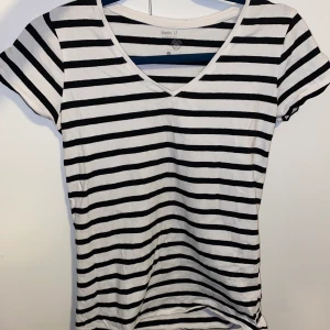 Randig t-shirt - Jättefin V-ringad T-shirt Stolek S. Den är vit med svarta ränder. Tycker jag tyvärr inte passar i randigt därför säljer jag den. Men modellen är jättefin! Om den hade varit enfärgad hade jag hade jag använt den varje dag🤍🖤 Vid intresse hur sitter på, dma 
