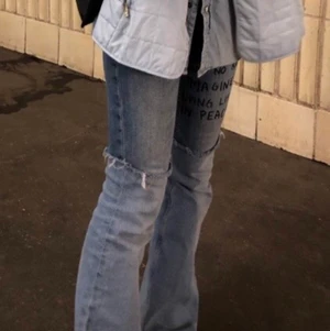 Regnskydda helt unika jeans - Jeans som jag sytt helt själv, finns ingen annan som har lika dana, ljusare jeanstyg nertill och mörkare upptill. Storlek 27/27 men ganska elastiska. Texten är början till Lennons imagine. Priset är prutbart