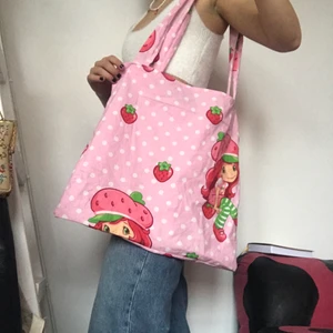 Strawberry shortcake tygväska  - Strawberry shortcake tygväska sydd av mig så one of a kind! Kom privat vid intresse. Köpare betalar frakt. Väldigt rymlig, både skolböcker och dator får plats. Checka min instagram viridi.designs för mer!