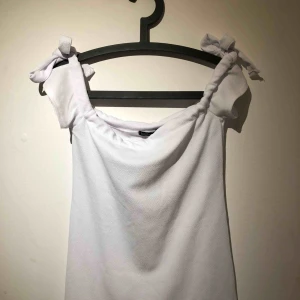  - En helt ny vit och fin offshoulder sommarklänning från Boohoo som man kan knyta på armarna.  Passar till bland annat student. Köparen står för frakt!  