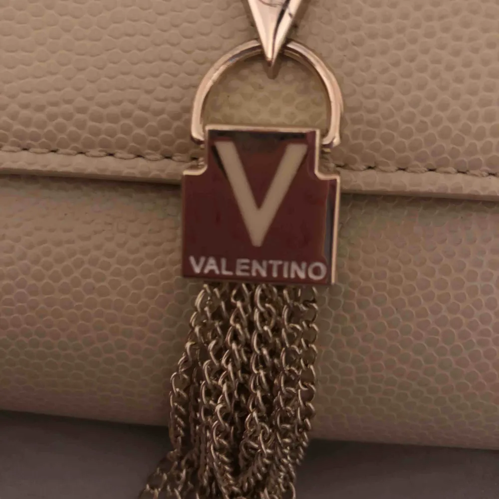 Äkta valentino väska, har silver kedja som band. Man kan även ta av bandet och använda till sin bal eller något. Använd 1 gång . Väskor.