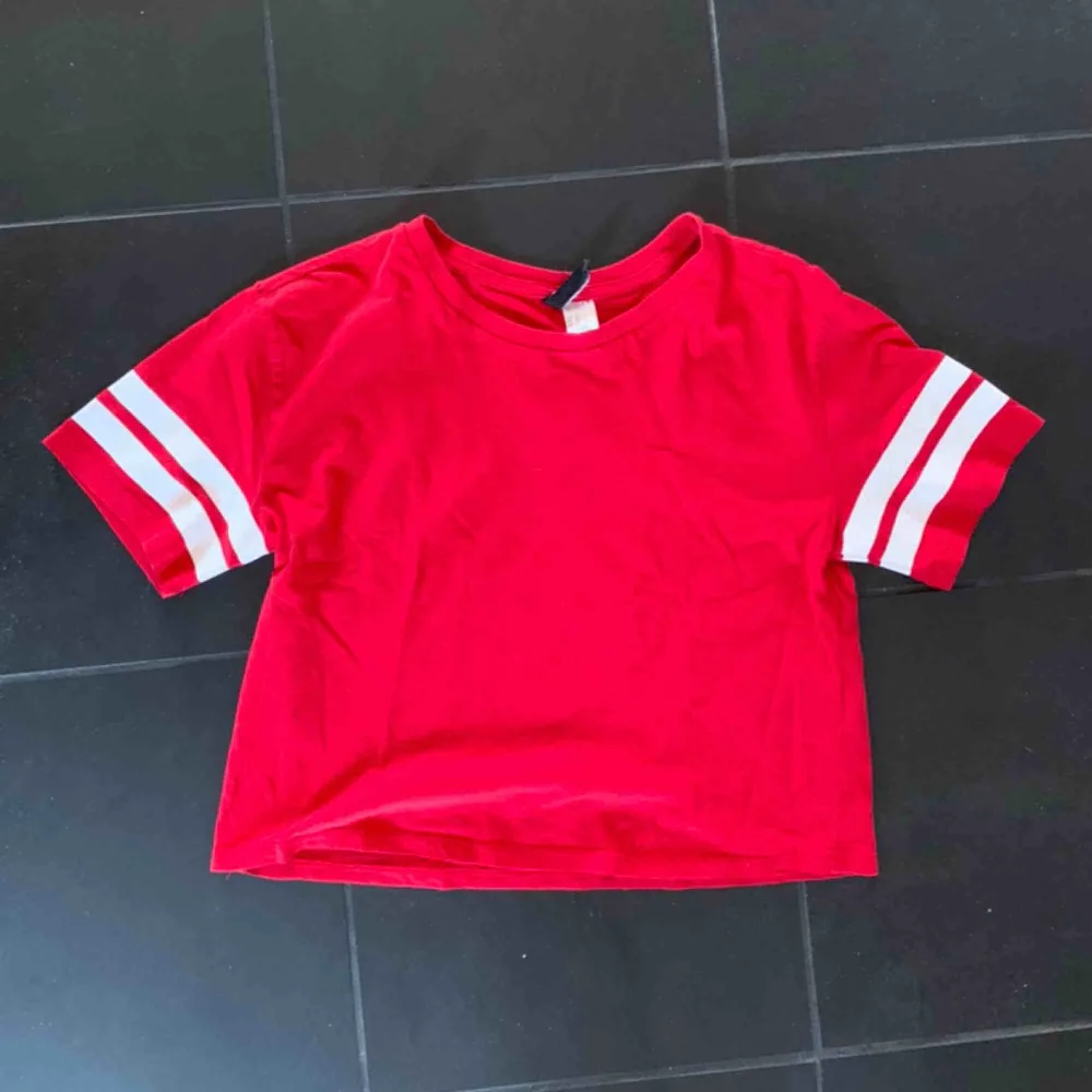 En röd t-shirt som går över naveln. . T-shirts.