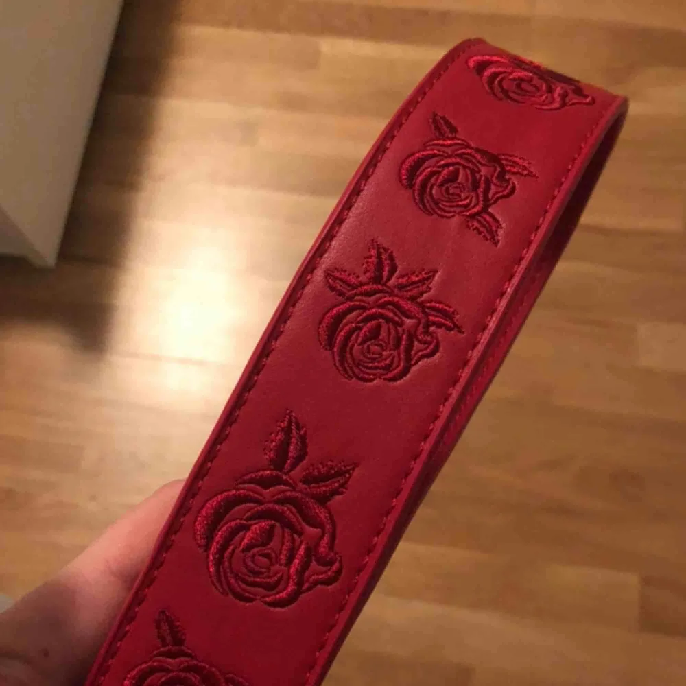 rött väsk-band (det har egentligen rosor på sig men de FÅTAL gånger jag använt det har jag använt det med ”fel” sida (den helt blanka sidan)) 😁. Accessoarer.