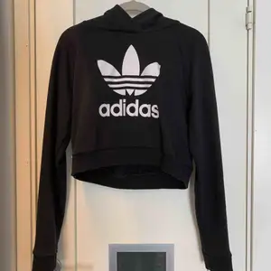 En svart croppad adidas hoodie med huva. Perfekt för träning och till vardags. Passar en XS-S, endast använd ett fåtal gånger. Original pris: 400kr. Säljs för 120+frakt. 