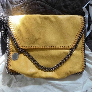  - Gul Stella McCartney helt oanvänd. Säljes pga jag inte får någon användning av den!  Bud: 1300 kr 