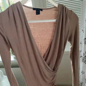 Omlott tröja. - Fin tröja, passar utmärk till fest. Sitter väldigt fint på och är väldigt stretchig. I en beige/rosa färg nude. Storlek xs men passar i S.