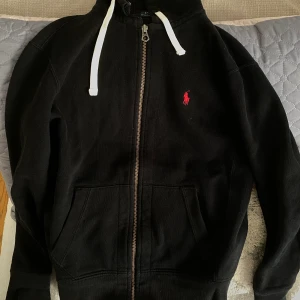 Ralph lauren hoodie - Tröjan har en flaw, som syns på ena bilden. Det är lätt att fixa och syns annars inte när man knyter luvan. Därför släpper jag den för ett så lågt pris jämfört med nypris. Den är storlek S och i bra skick förutom där den gått sönder.