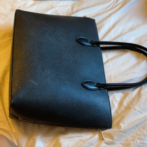 väska  - nedfällbara dragkedjor på sidan som gör väskan större. Ovikbara axelband 