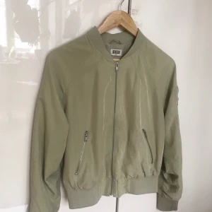 Ljus olivgrön tunn bomberjacka - Jättefin ljus olivgrön tunn bomberjacka, använd 1 gång. Weekday, strl S. 