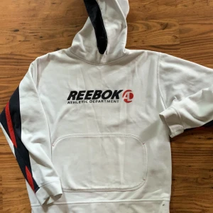 Vintage reebok hoodie - Denna Reebokhoodie är så snygg, särskilt till baggy jeans, och har en skön avslappnad passform. Coola meshdetaljer på ärmarna. OBS! Se bilder för små svårborttagna fläckar (har misslyckats med vanlig fläckborttagning, kanske funkar med klorin?)Buda gärna!