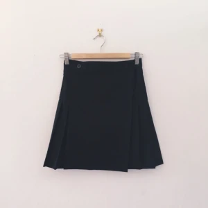  - Mörkblå, veckad omlottkjol från American Apparel. 