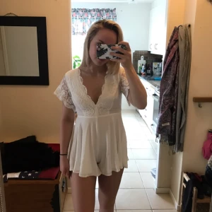  - Vit, söt playsuit från Hellomollyfashion.com.  Helt ny, oanvänd och bra kvalité. Prislapp + påse kvar.  Köptes för cirka 800kr men säljer för 600kr - priset går dock att diskuteras!   Perfekt till studenten/skolavslutningen! 