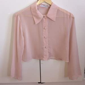 Tunn rosa skjorta av ganska kort modell med retro knappar i rosa/vitrutigt mönster.