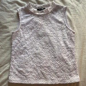 Turtleneck linne - Relativt kroppssydd med en lägre krage, spetsmönster med ett undertyg så att topen inte är genomskinlig. Nyskick men med en liten sminkfläck på kragen, se bild 3. Strlk 12 i barn men passar strlk xs/s perfekt