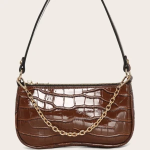 Liten Brun Väska med guldkedja  - En sprillans ny axelväska köpt från SHEIN. Väskan är i en jättefin brun färg som även kommer med en tjockare och smalare guldkedja. Aldrig kommit till användning så den är i nyskick! 100 kr + 60 kr frakt💕