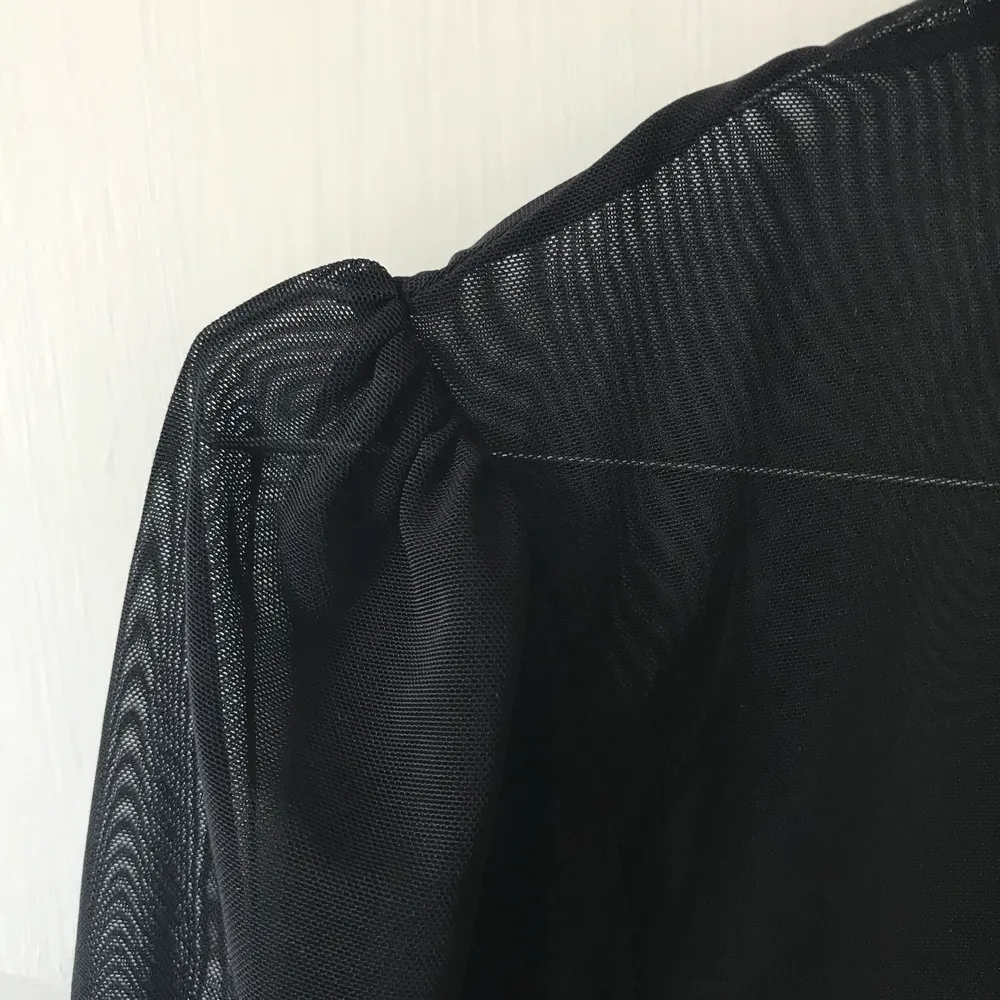 En svart mesh-tröja med puffärmar, passar vilken storlek som helst! . Toppar.