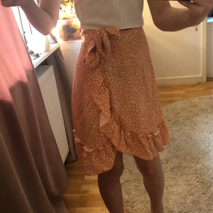 Orangeblommig kjol  - En orange kjol med blommigt mönster från Gina tricot i storlek xs