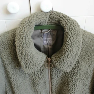 Militärgrön Teddyjacka från Primark - En teddyjacka! Köpt på Plick men ångrade mig efteråt då den inte riktigt är min stil. Men jag hann sätta mig på en nymålad bänk, därför har den en faluröd fläck vid ena fickan. Det är sänkt pris för det såklart! Skriv om du har frågor ❤