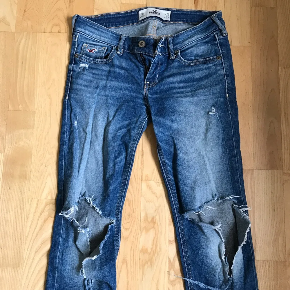 Blåa jeans med hål på knäna från Hollister, W25 L33. Jeans & Byxor.