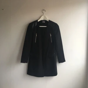  - Svart kappa med skinndetaljer. Sparsamt använd!