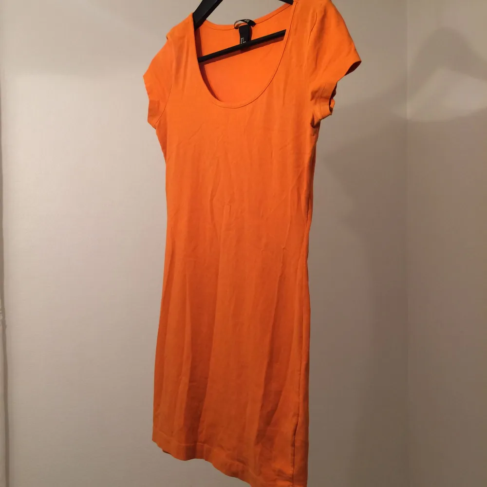 Härlig orange färg. Fodralklänning som när till halva låren ungefär.  Upphämt eller frakt . Klänningar.