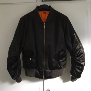  - Bomberjacka i mörk olivgrön. Dragkedja o knappar i guld.