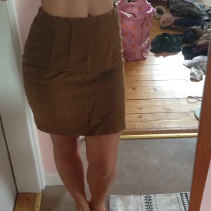  - Vintage kortare pennkjol i ljusare brun. Fin till hösten! Dragkedja baktill med litet sprund under rumpan. 