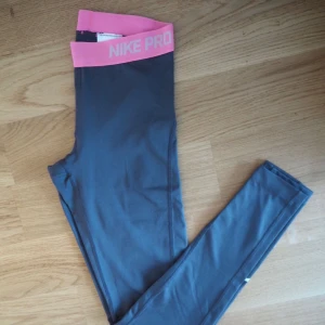  - Tights från Nike Pro. Gråa med rosa detaljer upptill. Storlek XS. Använda 2-4 gånger
