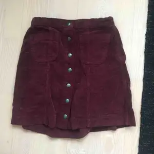 Fin kort kjol i Manchester tyg, knappar i mitten och fickor. Snygg vinröd färg! Från Brandy Melville😀 Köpare står för frakt:)