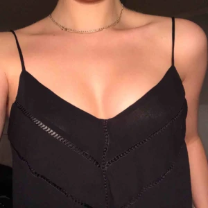  - Svart linne från zara i tunt blus-material! V-ringat både fram och bak, har superfina detaljer på framsidan som syns på bilden💕 köpare står för eventuell frakt!