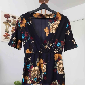  - 🔥MÖNSTRAD MÖRKBLÅ TOPP🔥Gjord i fint material med blommigt mönster🌼 V-ringad och avklippt längst ner = lite trådar🌼 Frakt går på 30 kr! Möts gärna upp i Göteborg!