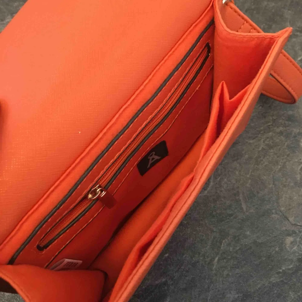 Orange väska 20x17cm.  Den är endast använd en gång så ser ut som ny! 60kr plus frakt. . Väskor.
